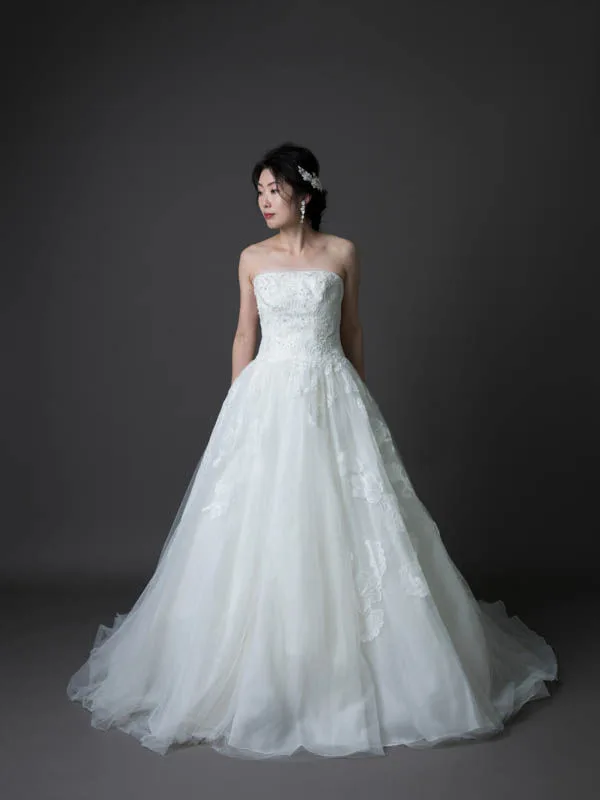 グレーの背景で、WHITE by Vera Wang のチュールドレスを着た花嫁